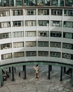 The ring-shaped building was formerly the BBC Television Center. A refurbished Helios statue stands in the courtyard. 