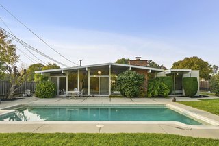 The backyard boasts a swimming pool, established fruit trees, and Concord grapes. 