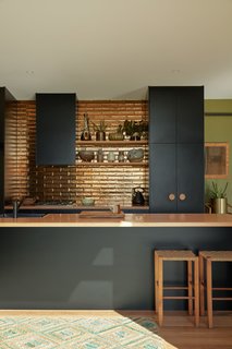 The kitchen backsplash tiles are Perini tiles in jaca bronze, their metallic glaze reflecting the natural light. 