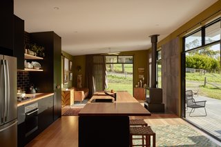 Extensive glazing keeps the open-plan living space bright and airy and provides expansive views, allowing the couple to immerse themselves in their rural surroundings. The hearth is a Horama Fireplace by Chiminees Philippe. 