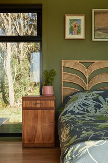The main bedroom has a skylight positioned above the bed, connecting the space to the surrounding nature and flooding it with natural light. 