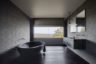 The dramatic, handmade, black concrete soaking tub is from Boyd Alternatives, a local Victorian company that produces handmade baths. The color is an addition to the concrete mix. 