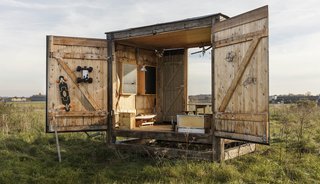 The studio's supporting posts are made of reclaimed timber. Large double doors allow the interior to open fully to the outdoors.