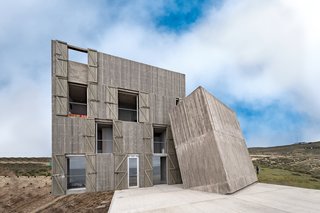 Two of the weathered concrete volumes lean against each other like building blocks. The main volume is spread over four levels. 