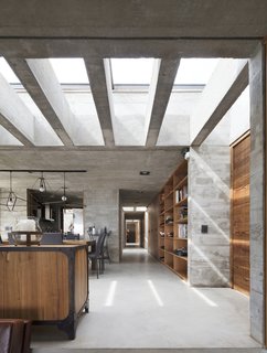 Rectangular skylights help bring natural light into the home, offsetting the heaviness of the concrete volume.