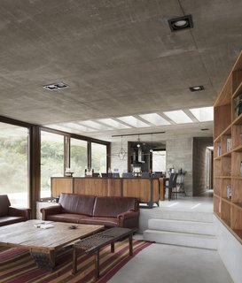 A full-height wall of glass brings additional natural light into the open-plan living area. The step down creates a cozy divide in the space.