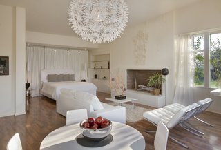 The guesthouse bedroom is modest and comfortable, with its own fireplace. 