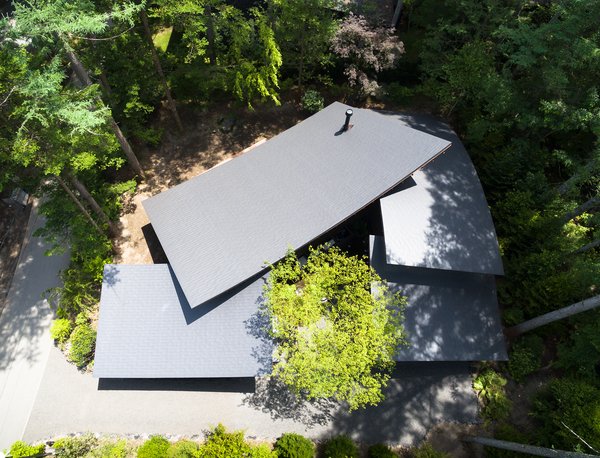 Viewed from above, the home wraps around itself and is folded around a small central courtyard. The roof sections overlap in an organic way, giving the home its name: Four Leaves.