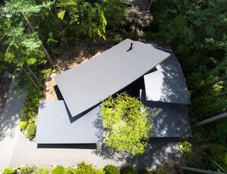 Viewed from above, the home wraps around itself and is folded around a small central courtyard. The roof sections overlap in an organic way, giving the home its name: Four Leaves. 