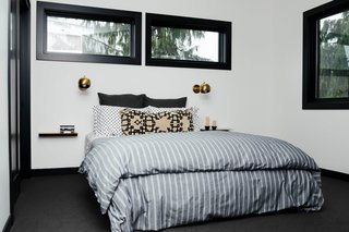 The master bedroom has bedding from Schoolhouse and an Isaac Sconce in brass. 