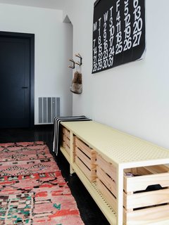 The entryway is designed for gear management with hooks and a custom-made bench with storage baskets. The floors are made of durable, hospital-grade FLEXCO radial high-profile rubber. The colorful rug from Kat + Maouche softens up the stark interior.
