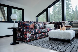 The living area is layered with prints and textures—including a bespoke sofa print inspired by a Dutch masterpiece from the Rijksmuseum. The herringbone rug, side table, and Matter Lamp are from Schoolhouse. The ottoman is from Pottery Barn Kids. 