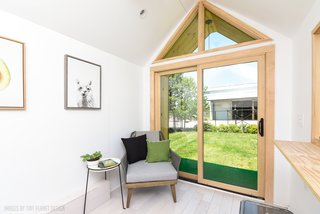 The living space overlooks a three-foot-wide covered patio with artificial turf.