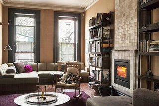 The cozy parlor-floor living room is anchored by a fireplace from the Dutch company Rais.