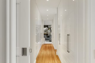 A hallway full of storage space leads to a media room.