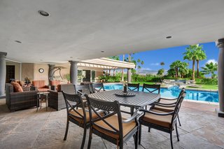 The covered outdoor living/dining/entertaining area overlooks the pool. 