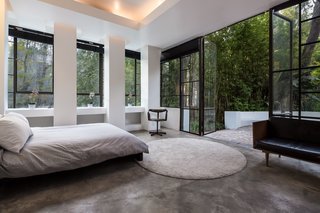 The home has three bedrooms and three baths. This bedroom features full-height doors leading to an outdoor terrace. 
