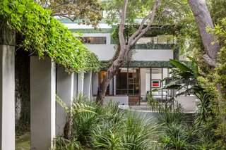 The four-level, 2,690-square-foot home's oxidized copper elements almost blend into the surrounding greenery.