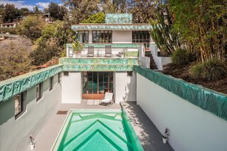 A view of the pool and a rooftop deck which overlooks the outdoor space. 