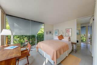 The bedroom features expansive windows.