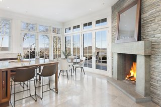 The kitchen also includes a small dining area and a stone fireplace. 