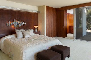 The master suite features wood paneling and extensive glazing, in keeping with the design of the home.