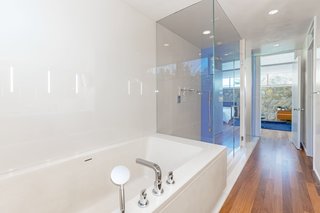 The renovated master bathroom features minimalist, glossy finishes. 