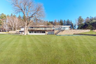 The midcentury modern home is located on 1.7 acres of land and features bluestone terraces, fieldstone walls, and elevated views of the countryside.
