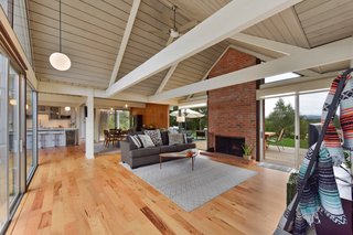 The living space is anchored by a brick-inlay fireplace with expansive glazing on either side, also a key Eichler feature. 