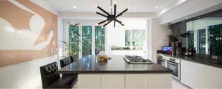 The sleek, modern kitchen is perfect for cooking and entertaining, with a large island and designer appliances. 
