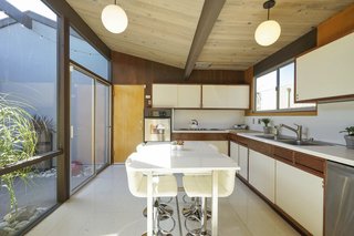 The galley kitchen has original cabinetry and countertops, all in excellent condition. Updated stainless-steel appliances and a large pantry outfit the kitchen, which has direct access to the atrium and the enormous, two-car garage.