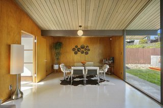 The dining room is warmed by the original mahogany, paneled walls and globe pendant lighting. 