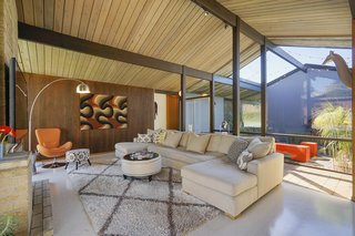The home's post-and-beam construction accentuates the indoor/outdoor flow, leading the eye straight from the central atrium to the backyard on the opposite side. 