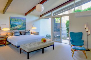 The master bedroom also enjoys outdoor access, while a vaulted ceiling contributes to a sense of space.