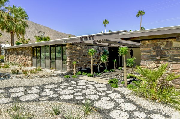 The long, low-slung facade of carefully masoned stone helps integrate the home into its desert surroundings.&nbsp;