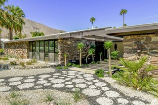 The long, low-slung facade of carefully masoned stone helps integrate the home into its desert surroundings. 
