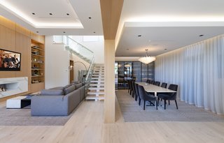 Light wood flooring warms the interior. A Baccarat chandelier hanging over the dining table adds a bit of sparkling star quality.
