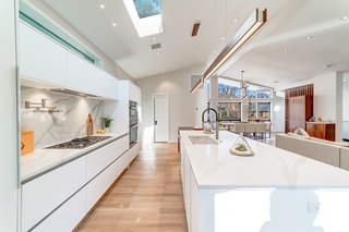 The open kitchen features a large center island, an overhead skylight, and ample storage.&nbsp;