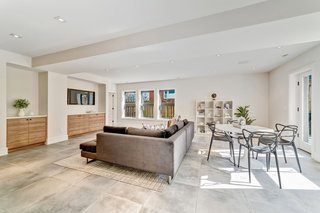 The lower-level family room has a wet bar, a kitchenette, and doors leading to the backyard.