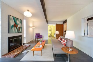 The ceilings are painted white, providing an open feel. Dark beams run the width of the home.&nbsp;