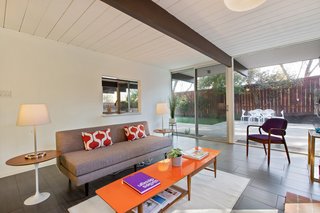 The living room overlooks the backyard through a wall of glass.