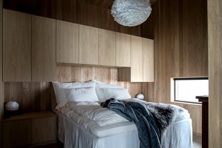 At the back of the cabin, there is a master bedroom, a bathroom, and a sauna that ingeniously doubles as a guest room.&nbsp;