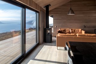 Inside, oak flooring and paneling reflect the colors of the natural surroundings. Large glass sliding doors bring the outdoors into the living room.<br>&nbsp;<span style="color: rgb(204, 204, 204); font-size: 13px;">Photo by Marte Garmann</span>