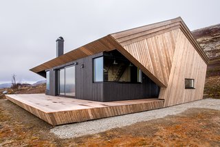 The angled pine paneling set against the black cabin body creates a strong geometric form.&nbsp;