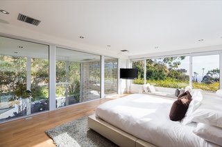 The bright and airy master bedroom has windows overlooking the living room below.