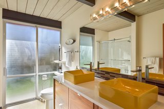In the guest bath, a glass sliding door leads outside. 