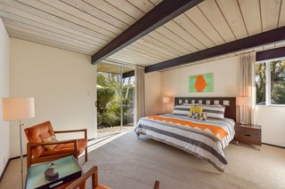 The master suite has a split bath with modern fixtures and a "tiled Roman spa shower" with a glass sliding door that leads to the garden.