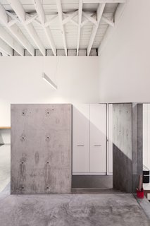 The walls and ceiling were whitewashed and new concrete was poured to give the workspace a clean and minimal palette. 
