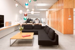 A custom Bocci 28 copper chandelier hangs above a black wool sectional by Bensen.