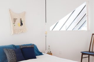 The triangle peek-hole in the upstairs bedroom allows light to pour in from the central skylight.